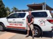 Smoke Alarm Services technician standing in front of work ute.